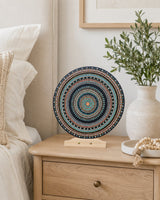 Copper Jewel dot mandala artwork displayed on a timber stand beside a bed in a soft neutral bedroom by Sweet Lilly Loves