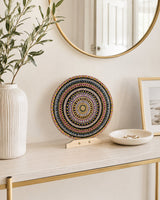 Crown of Echoes copper, pink and teal dot mandala artwork displayed on a console beneath a round mirror by Sweet Lilly Loves