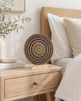Crown of Echoes gold and teal mandala artwork displayed on a bedside table in a soft neutral bedroom by Sweet Lilly Loves