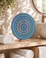 Divine Tide of Gold round dot mandala artwork displayed on a stand beside folded towels in a soft neutral interior by Sweet Lilly Loves