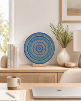 Divine Tide of Gold round dot mandala artwork displayed on a stand on a light desk with neutral decor by Sweet Lilly Loves
