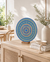 Divine Tide of Gold original hand-painted mandala artwork displayed on a stand on a light console table by Sweet Lilly Loves