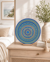 Divine Tide of Gold original blue and gold mandala artwork displayed on a timber stand on a light cabinet by Sweet Lilly Loves