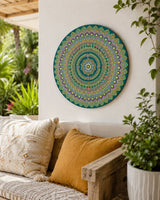 Emerald Echo Aurelia hand-painted dot mandala artwork displayed on a light outdoor wall above a mustard cushion bench by Sweet Lilly Loves