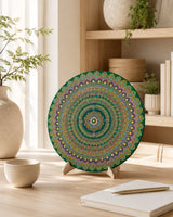 Emerald Echo Aurelia round dot mandala artwork displayed on a stand on a light table with books and decor by Sweet Lilly Loves