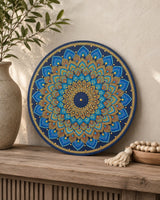 Just Blooming Golden Blue hand-painted dot mandala artwork displayed on a timber surface beside a vase and neutral decor by Sweet Lilly Loves