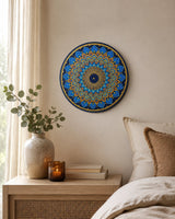 Just Blooming Golden Blue original hand-painted mandala artwork displayed above a bedside table in a soft neutral bedroom by Sweet Lilly Loves