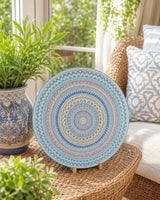 Ocean Whisper hand-painted dot mandala artwork displayed beside a cushioned chair in a light outdoor setting by Sweet Lilly Loves