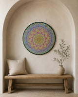 Radiant Pulse, colorful round mandala artwork, is displayed above a minimalist bench in an arched wall nook by Sweet Lilly Loves