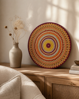Sunset Warm Winter Fire original round mandala artwork displayed on a bedside table in a soft neutral bedroom by Sweet Lilly Loves