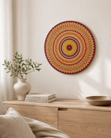 Sunset Warm Winter Fire original orange, red and gold mandala wall art displayed above a soft neutral bed by Sweet Lilly Loves