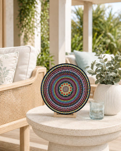 The Happy Centre original colourful dot mandala artwork displayed on a timber stand on a round stone side table by Sweet Lilly Loves
