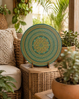 Verdant Glow hand-painted dot mandala artwork displayed beside plants in a light outdoor setting by Sweet Lilly Loves
